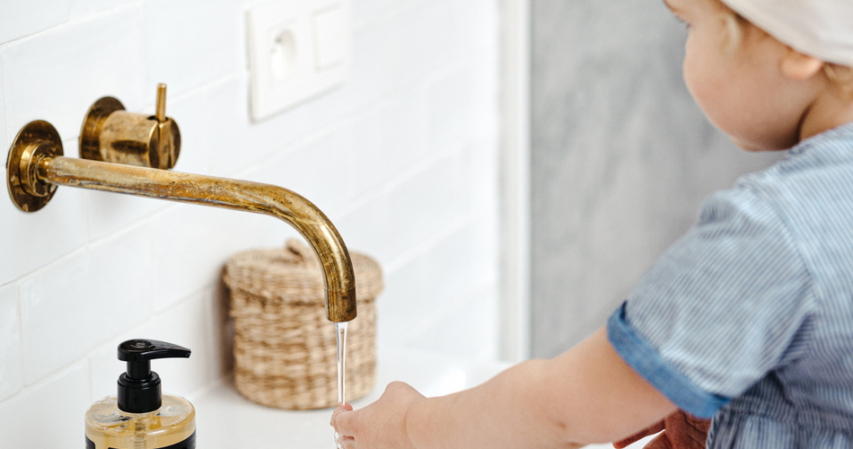 Kind wast handen onder een kraan
