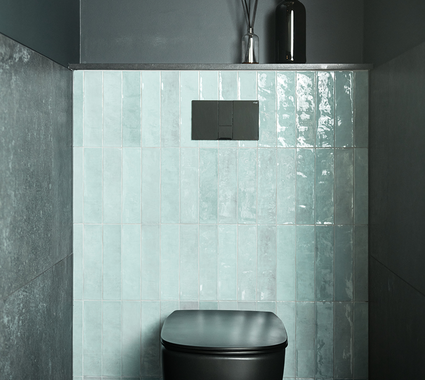 Modern toilet met zwarte pot, groene tegels op de achterwand en donkere muren voor een stijlvol contrast.