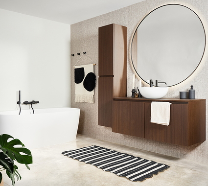Basic badkamer met betonvloer, walnoot meubel en ronde spiegel