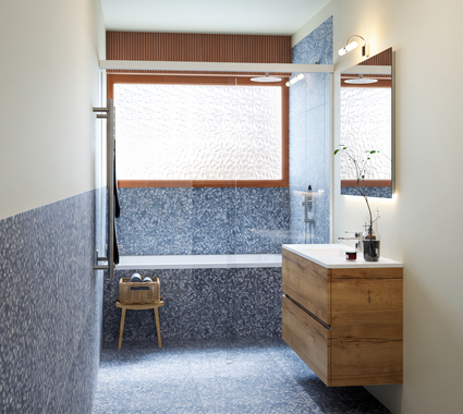 badkamer 170 x 300 cm met betegeld inbouw bad, douche en houten badkamermeubel. De onderste helft van de muren is bekleed met blauwe terrazzo tegels