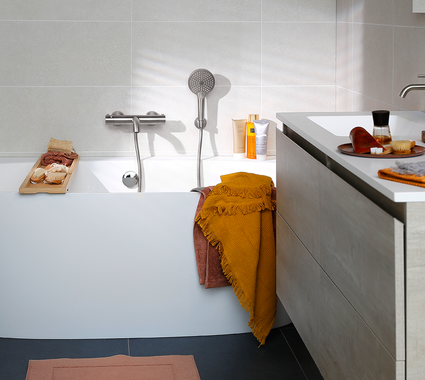 Kleine badkamer met badkamermeubel, bad, douche én toilet.