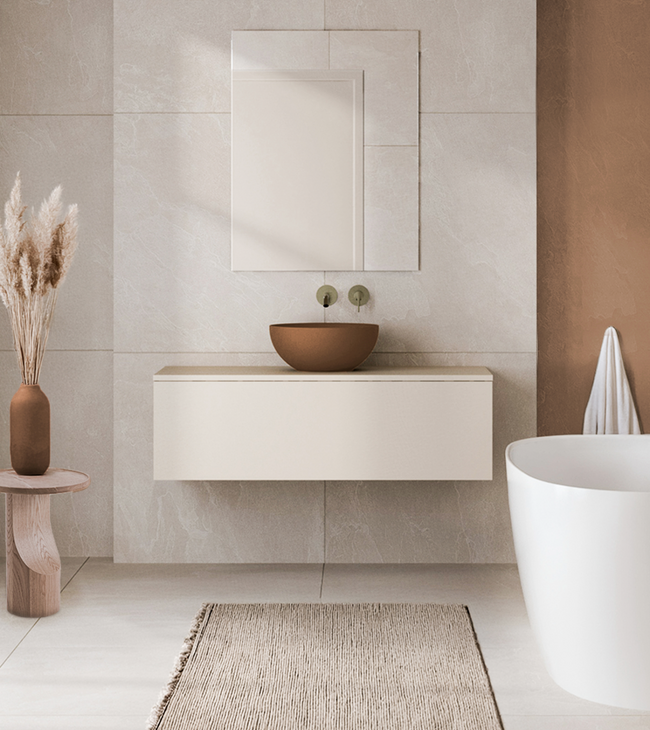 Minimalistisch badkamermeubel in beige met ronde opzetkom, grote spiegel en vrijstaand bad in een zachte, aardse kleurenpalet.