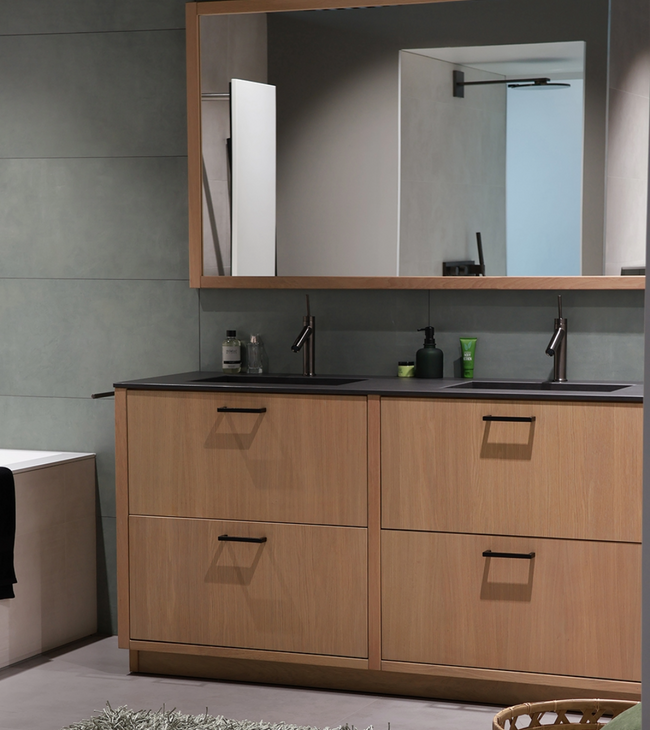 Badkamer met grote spiegel boven een dubbel wastafelmeubel in Biophilic design, omringd door natuurlijke materialen en tinten.