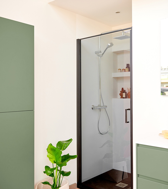 Douchedeur in nis met stijlvol getint glas en zwart frame, gecombineerd met zachte natuurtinten en moderne afwerking.