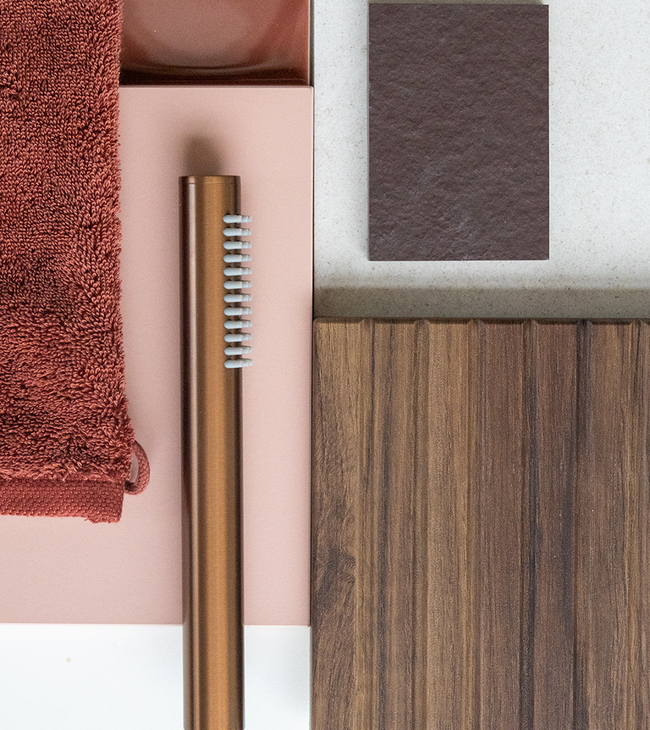 Moodboard met walnoot hout, roze en bruine tegels, koperen handdouche en roestbruine handdoek voor badkamerinspiratie.