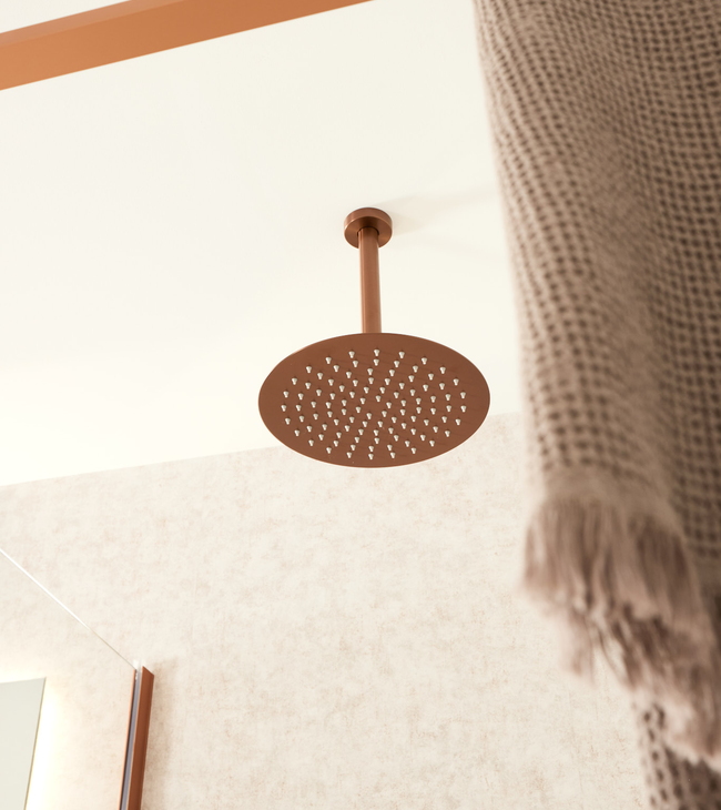Regendouche in geborsteld brons die stijlvol uit het plafond komt in een trendy badkamer met warme afwerking.