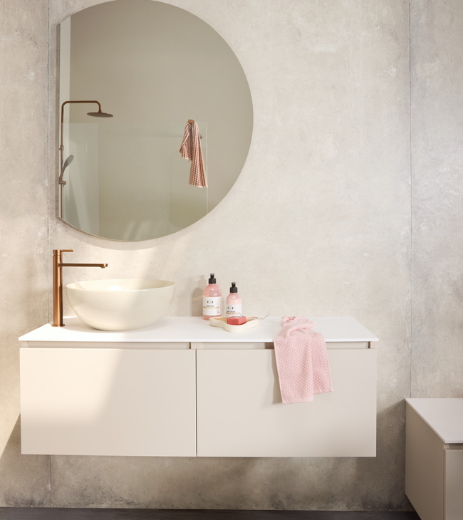 Beige badkamermeubel met beige omzetwaskom en wastafelkraan koper en halfronde spiegel