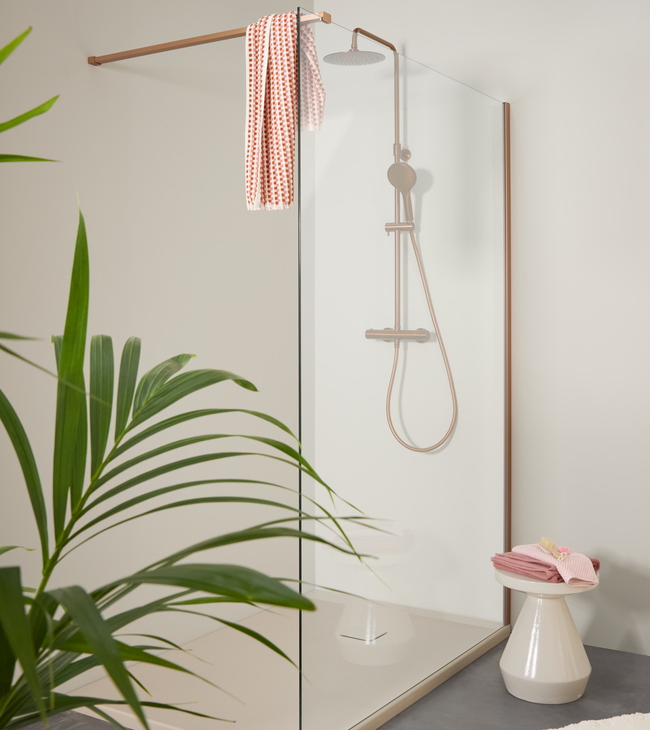 Inloopdouche met helder glas, bronzen details en een beige douchebak.