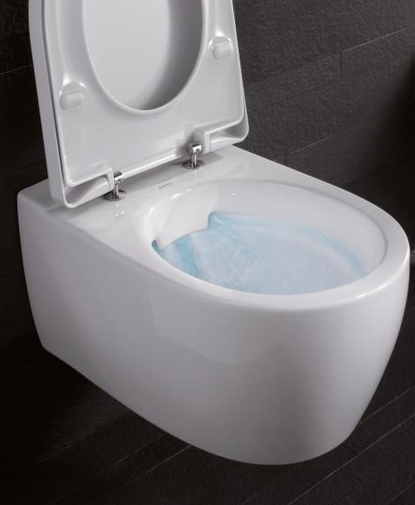 Wit hangend toilet met open deksel en spoelend water, geplaatst tegen een donkere tegelwand.