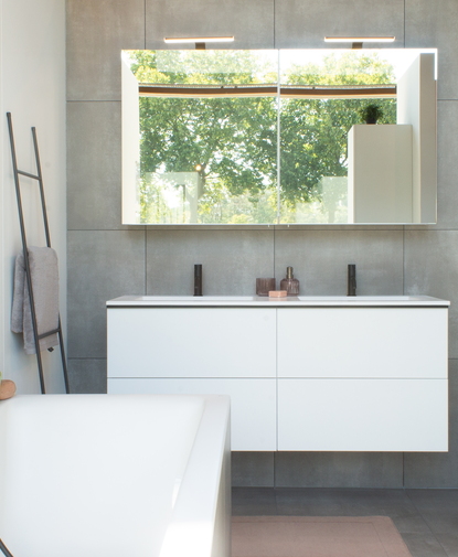Badkamer in stijl Modern met wit badkamermeubel, zwarte kranen, grijze tegels en vrijstaand bad met zwarte handdouche.