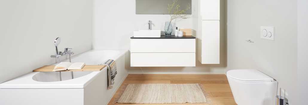 Moderne badkamer met wit inbouwbad, zwevend badkamermeubel, hangtoilet en houten vloer voor een strakke uitstraling.