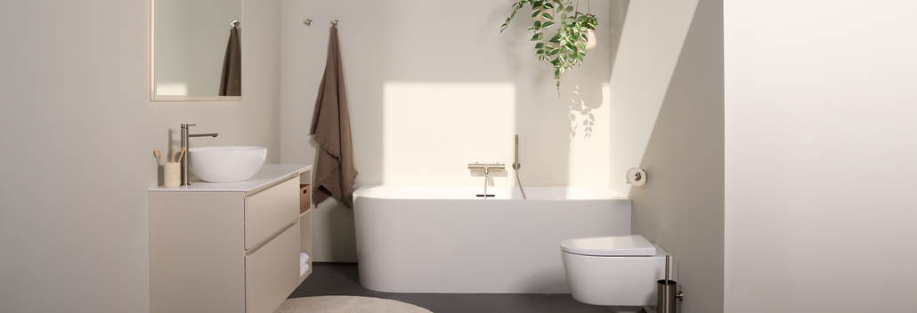 Minimalistische badkamer met half vrijstaand hoekbad, zwevend toilet en strak hangmeubel in neutrale tinten.